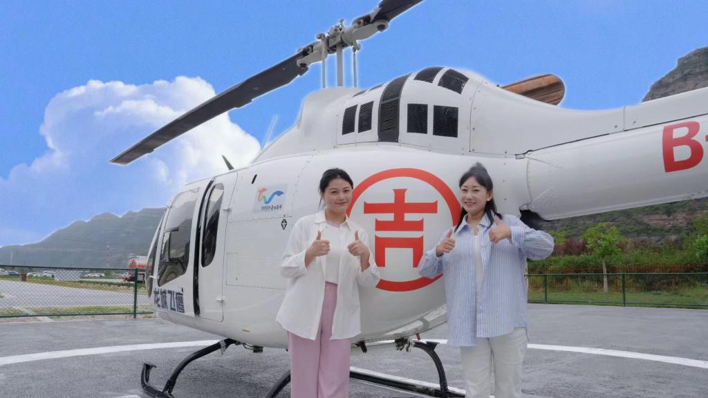 吉县壶口飞行基地里，游客乘坐直升机后拍照留念